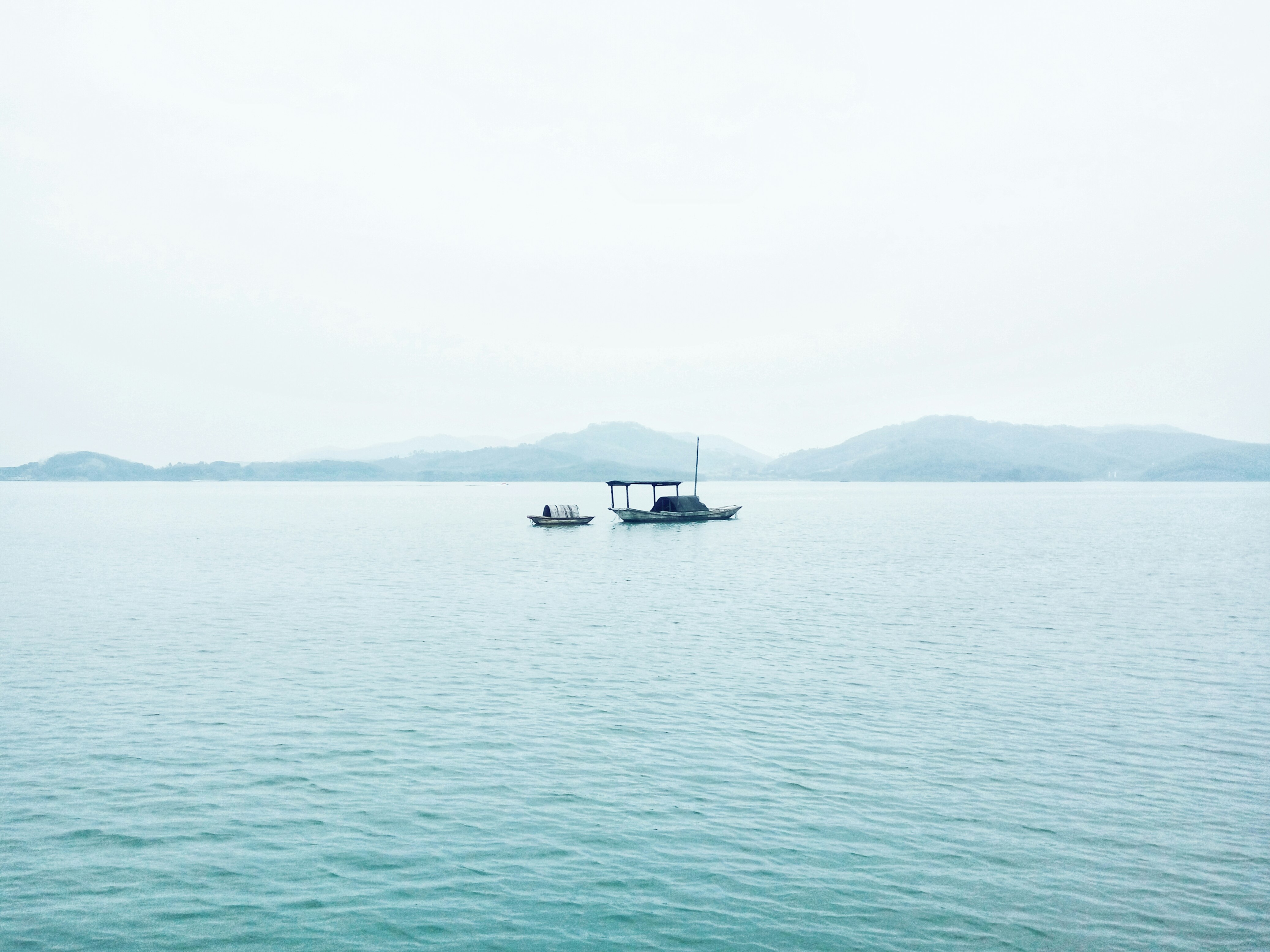 two white boats in middle of sea during daytime